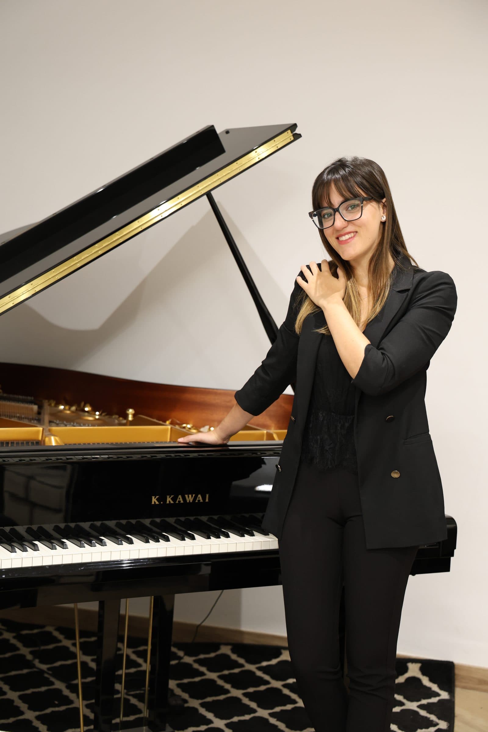 Laura Ortega de pie junto a su piano de cola Kawai GX-2